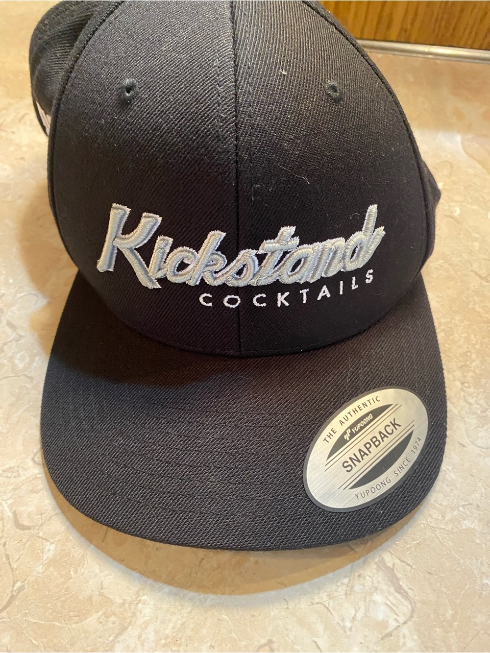 The Classic Black Snapback Hat with White 'Kickstand Cocktails' Embroidery